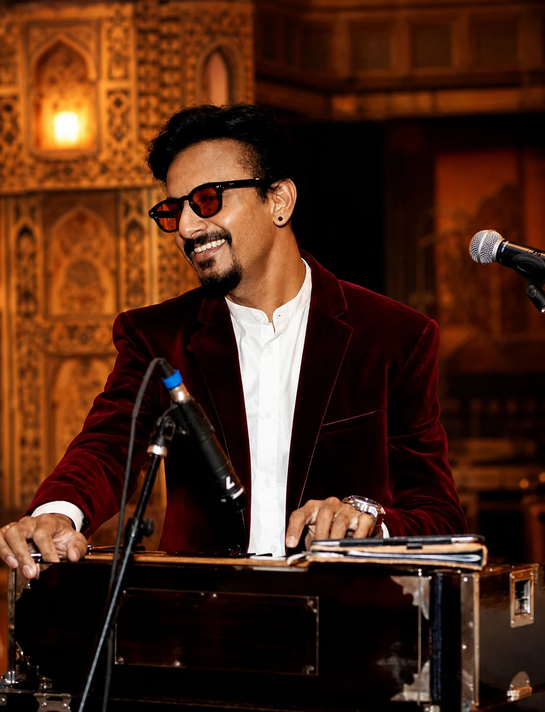 Prakash Parmar smiling during a live harmonium performance